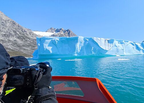 Vom Boot aus beobachtet die Gruppe einen strahlend blauen Gletscher