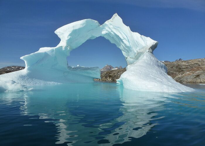 Eisberg im Sermilik Fjord im glasklaren blauen Wasser Grönlands