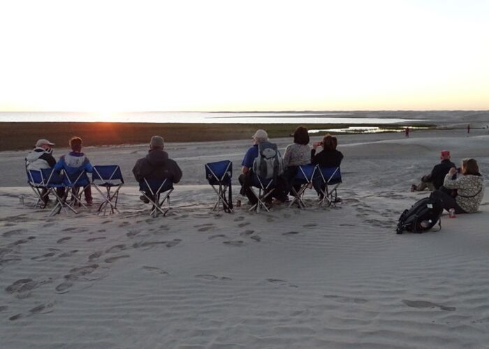 Die Gruppe genießt in der Bucht den Sonnenaufgang während der mehrtägigen Bootsexkursion